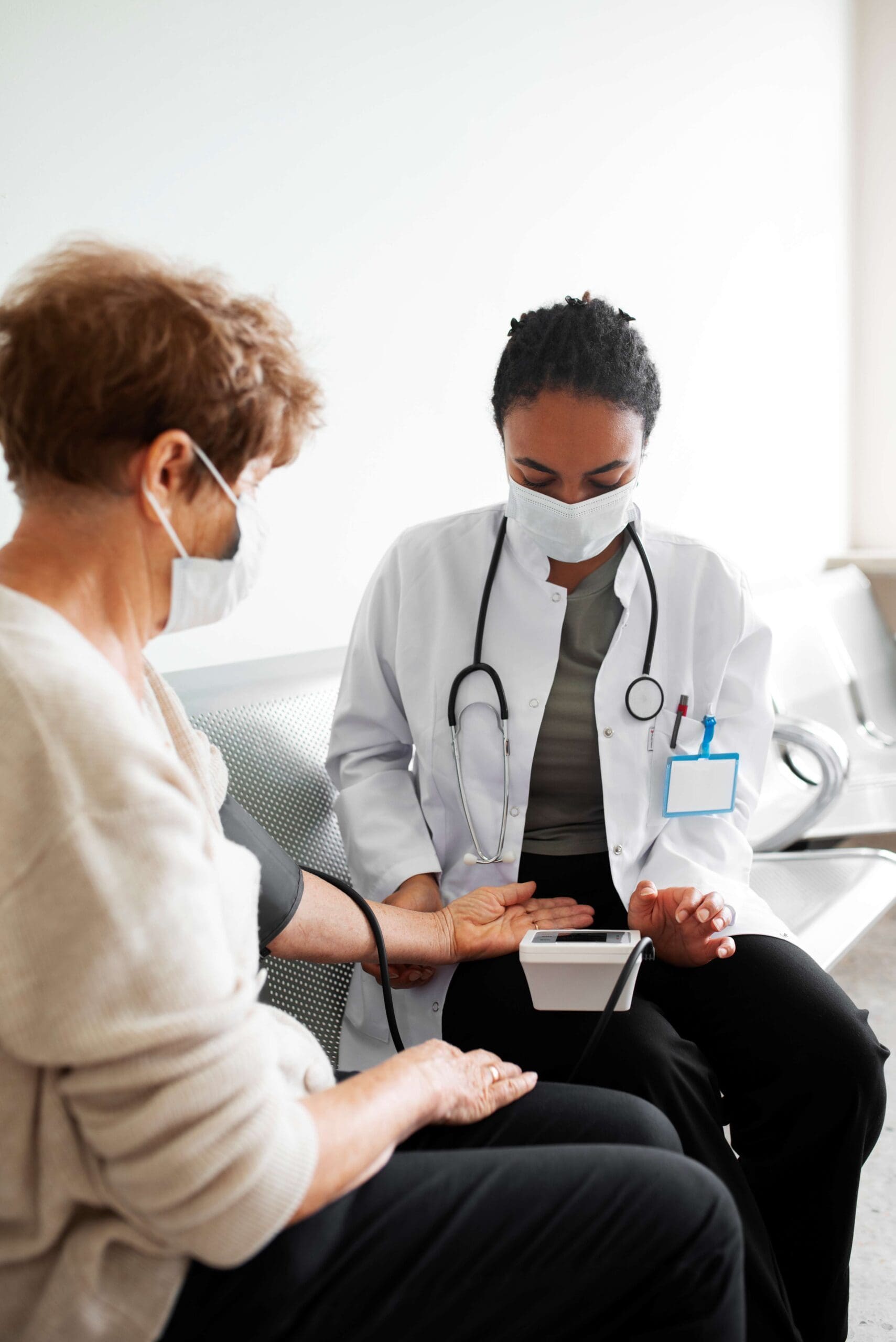 Doctor with facemask beside her is the patient